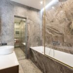 Modern bathroom with sink and faucet on counter near bath